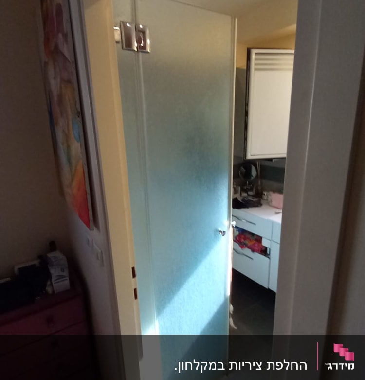 דלת זכוכית למקלחת עם מגבת על הרצפה